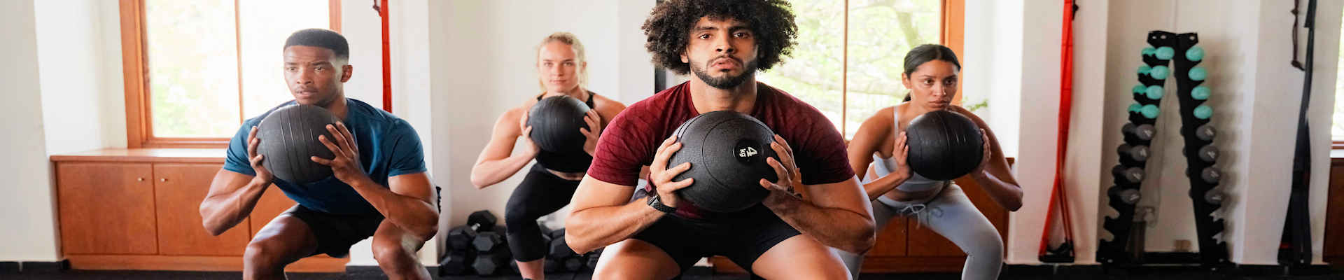 People squatting and holding ball